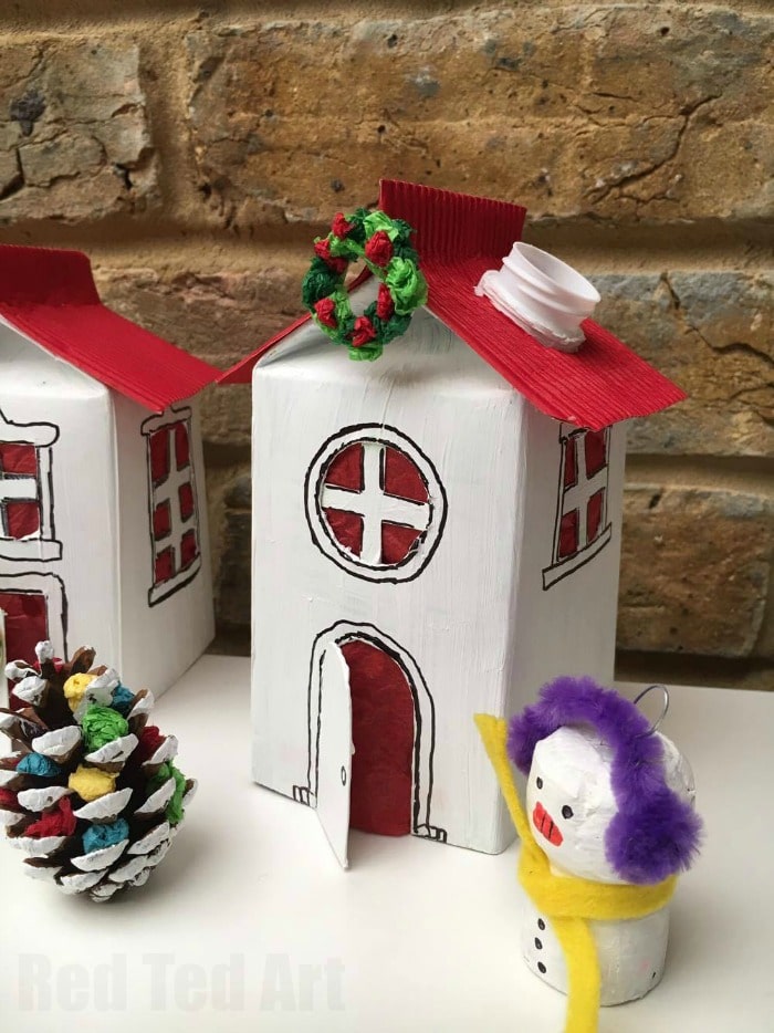 Winter Village Luminary DIY. We adore these cute Juice Carton Luminaries. They are fun to make and add a lovely little something to the Winter months. Use them as night lights or Christmas Decorations. Love adding lots of little details like mini pine cone Christmas Trees, snowmen and mini wreaths. All made mainly from recycled materials or nature finds!