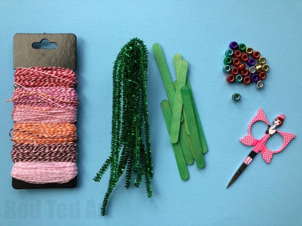 Pipecleaner Christmas Tree Ornaments - super cute and simple craft stick and pipecleaner tree ornaments. The kids will love to make these and they are great for fine motor skills. We made these at the school fair and they went down a treat! #Christmas #Christmastree #preschool #pipecleaner #ornaments