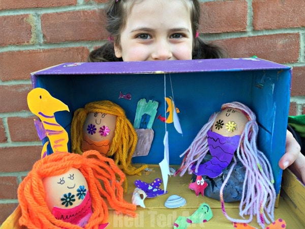 girl holding a diaorama made form mermaid eggs and a shoe box