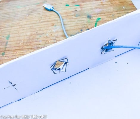 Making holes for the electronics in a DIY Desk Origaniser from a cardboard box