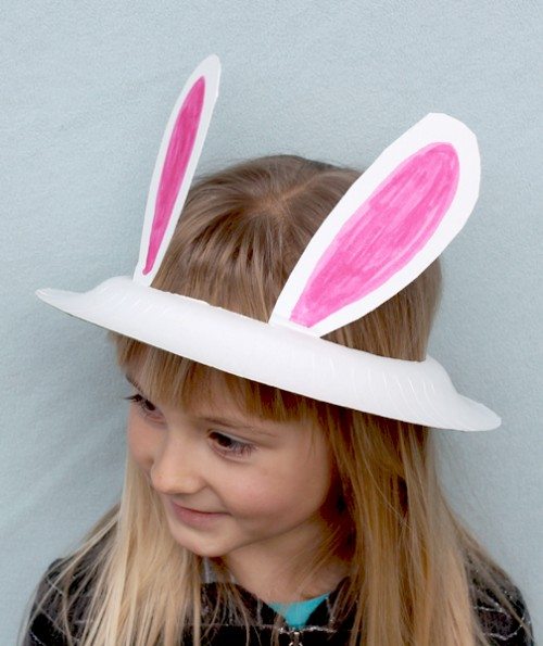 preschooler wearing a paper plate bunny ears hat