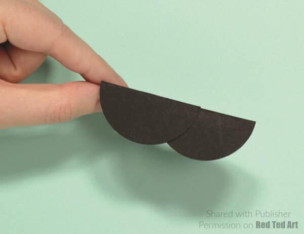 fold the paper circle in half and make a body